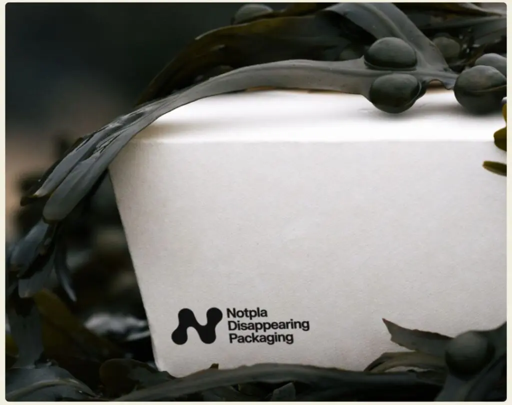 Close-up photograph of Notpla's food container, bearing their logo and "Notpla Disappearing Packaging"